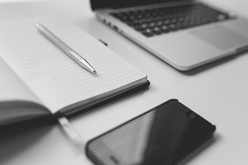 laptop, paper notebook and phone